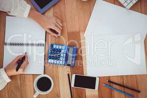 Cropped image of woman writing on notepad