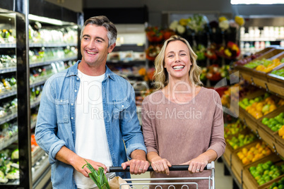 Smiling bright couple buying food products