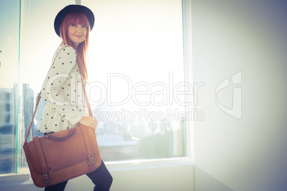 Portrait of a smiling hipster woman with a bag