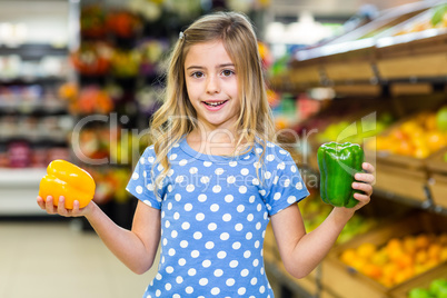 Smiling girl holding two pepper