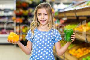 Smiling girl holding two pepper