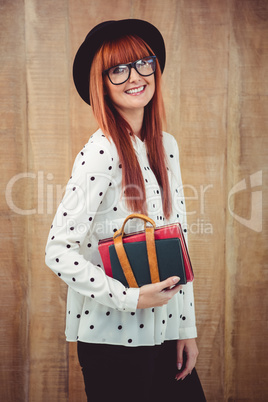 Smiling hipster woman holding book belt