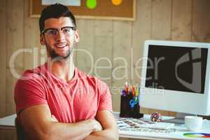 Smiling hipster sitting at his desk