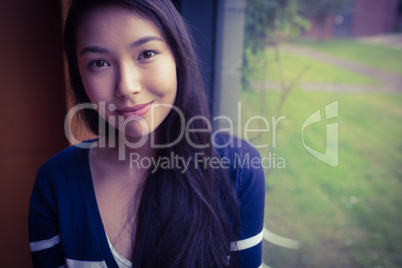 Smiling student leaning against the glass window