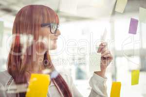 Attractive hipster woman looking at sticky notes