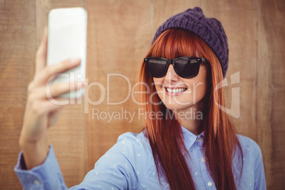 Smiling hipster woman taking selfie