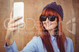 Smiling hipster woman taking selfie