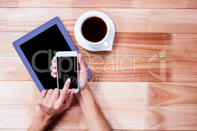 Businesswoman using her smartphone on desk