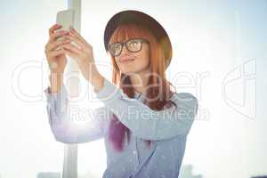 Smiling hipster woman taking selfie