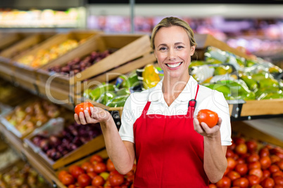 Portrait of smiling seller holding tomatoes