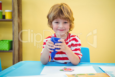 Small boy using a bottle of glue