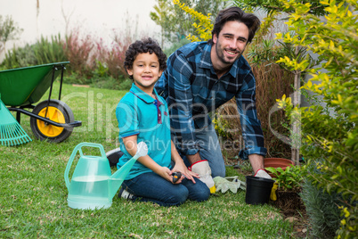 Smiling father and son gardening