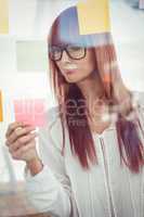 Attractive hipster woman looking at sticky notes