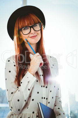 Smiling hipster woman writing notes