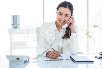 Smiling businesswoman using her telephone