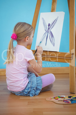 Happy girl sitting and painting a picture