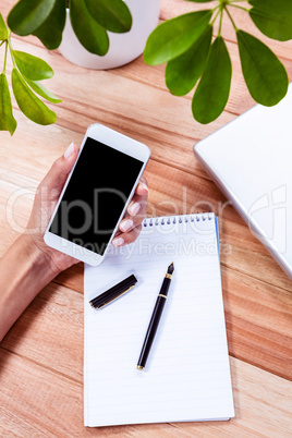 Overhead of feminine hands holding smartphone Overhead of feminine hands holding smartphone