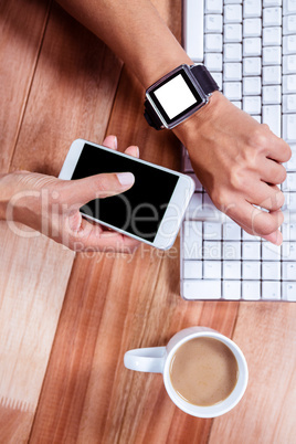 Feminine hands with smartwatch using smartphone