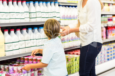 Mother and son looking at the supermarket fridge
