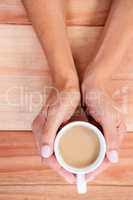 Womans hands holding cup of coffee