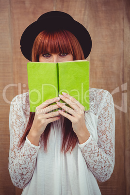 Hipster woman behind a book