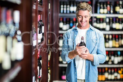 Smiling man holding bottle of wine