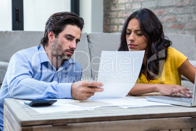 Couple in living room paying bills