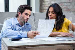Couple in living room paying bills