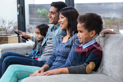 Happy young family watching tv