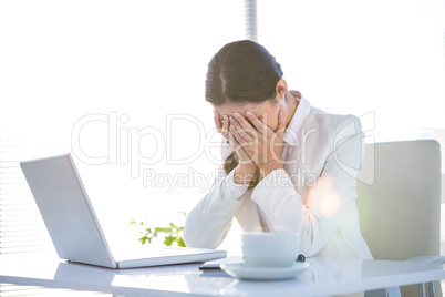 Worried businesswoman covering face