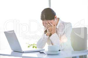 Worried businesswoman covering face