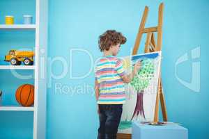 Happy boy painting his picture