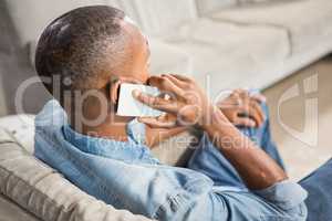 Over shoulder view of casual man using smartphone