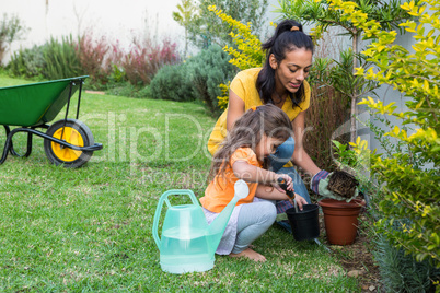 Smiling mother and daughter gardening