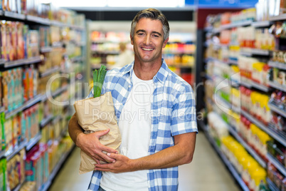 Smiling man holding grocery bag