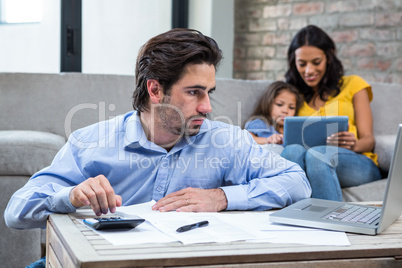 Serious man paying bills in living room