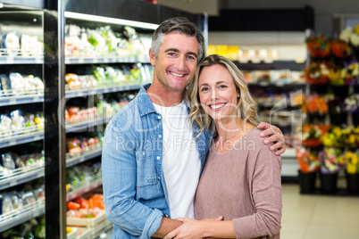 Smiling couple hugging in fruit aisle