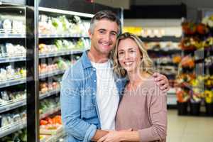 Smiling couple hugging in fruit aisle