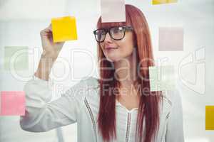 Attractive hipster woman writing on sticky notes