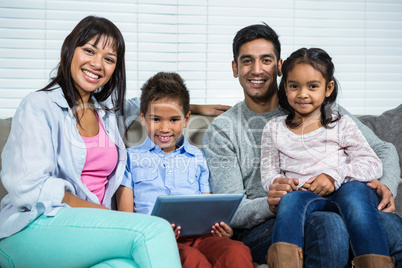 Smiling family on the sofa with tablet