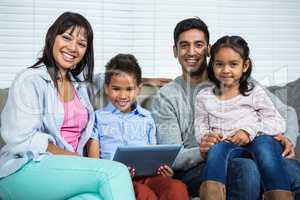 Smiling family on the sofa with tablet