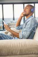 Happy handsome man listening music with headphones