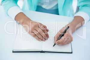 Businesswoman writing into her notepad