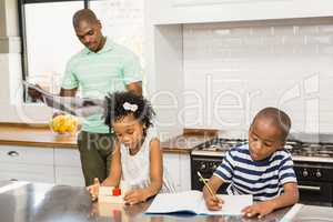 Children playing and drawing in the kitchen