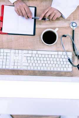 Doctor holding pen on desk