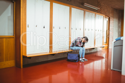 Worried student sitting with hands on head