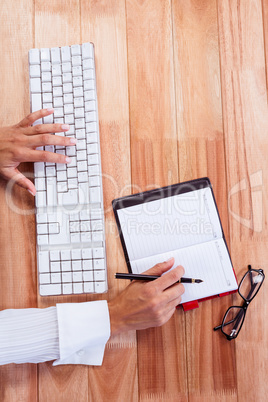 Part of hands typing on keyboard