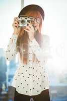 Smiling hipster woman taking pictures
