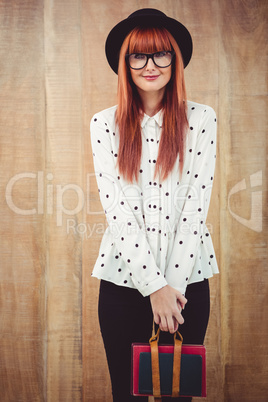 Smiling hipster woman holding book belt