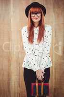 Smiling hipster woman holding book belt